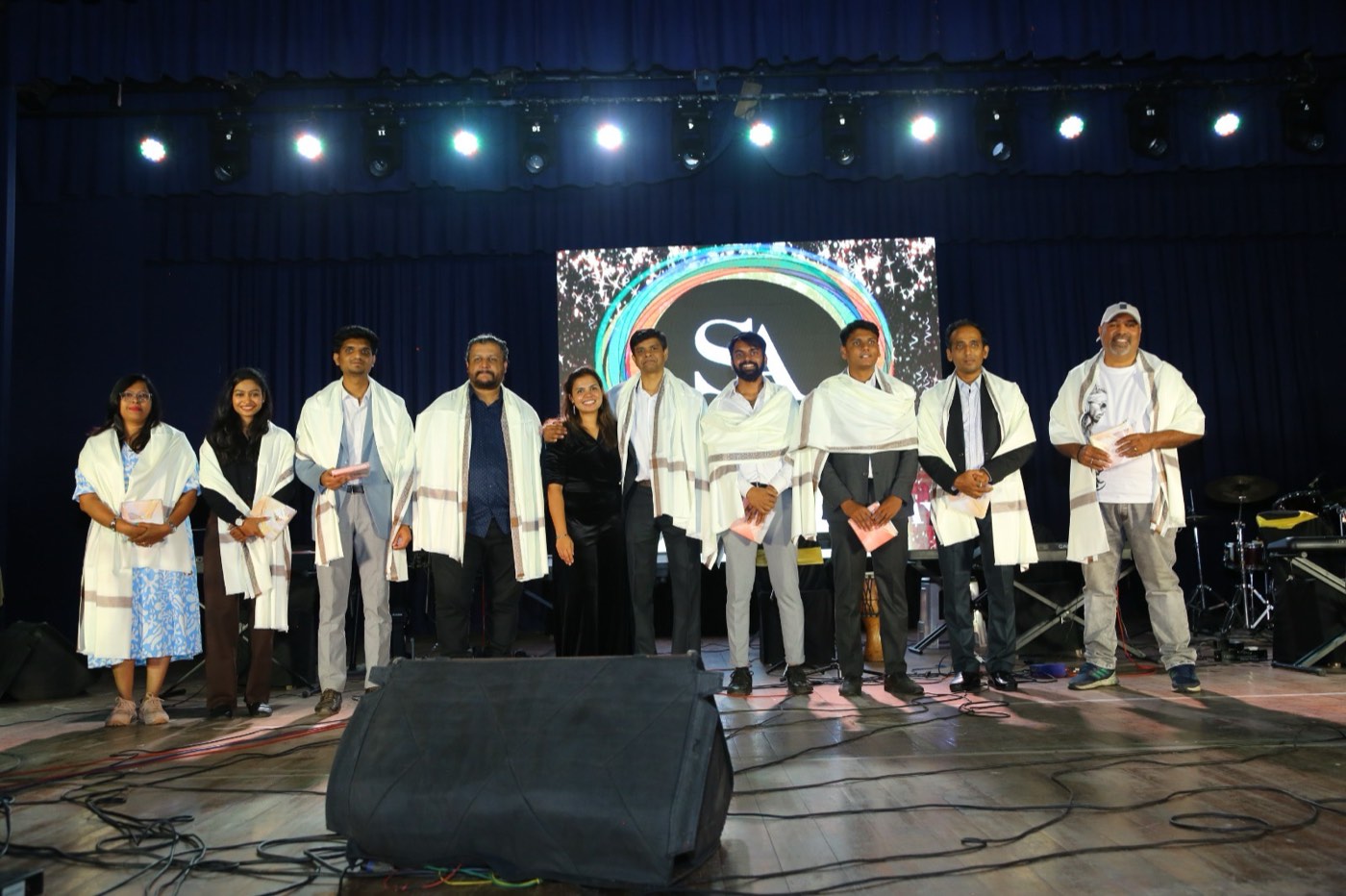 Guests being felicitated on stage in front of the LED wall